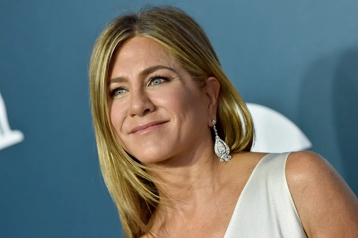 jennifer aniston posing at the Annual Screen Actors Guild Awards in a white dress.