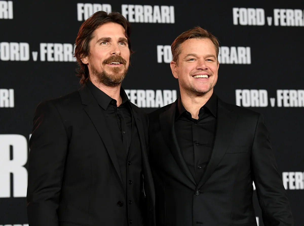 Matt Damon and Christian Bale posing in matching-colored suits at the 'Ford v Ferrari' premiere.