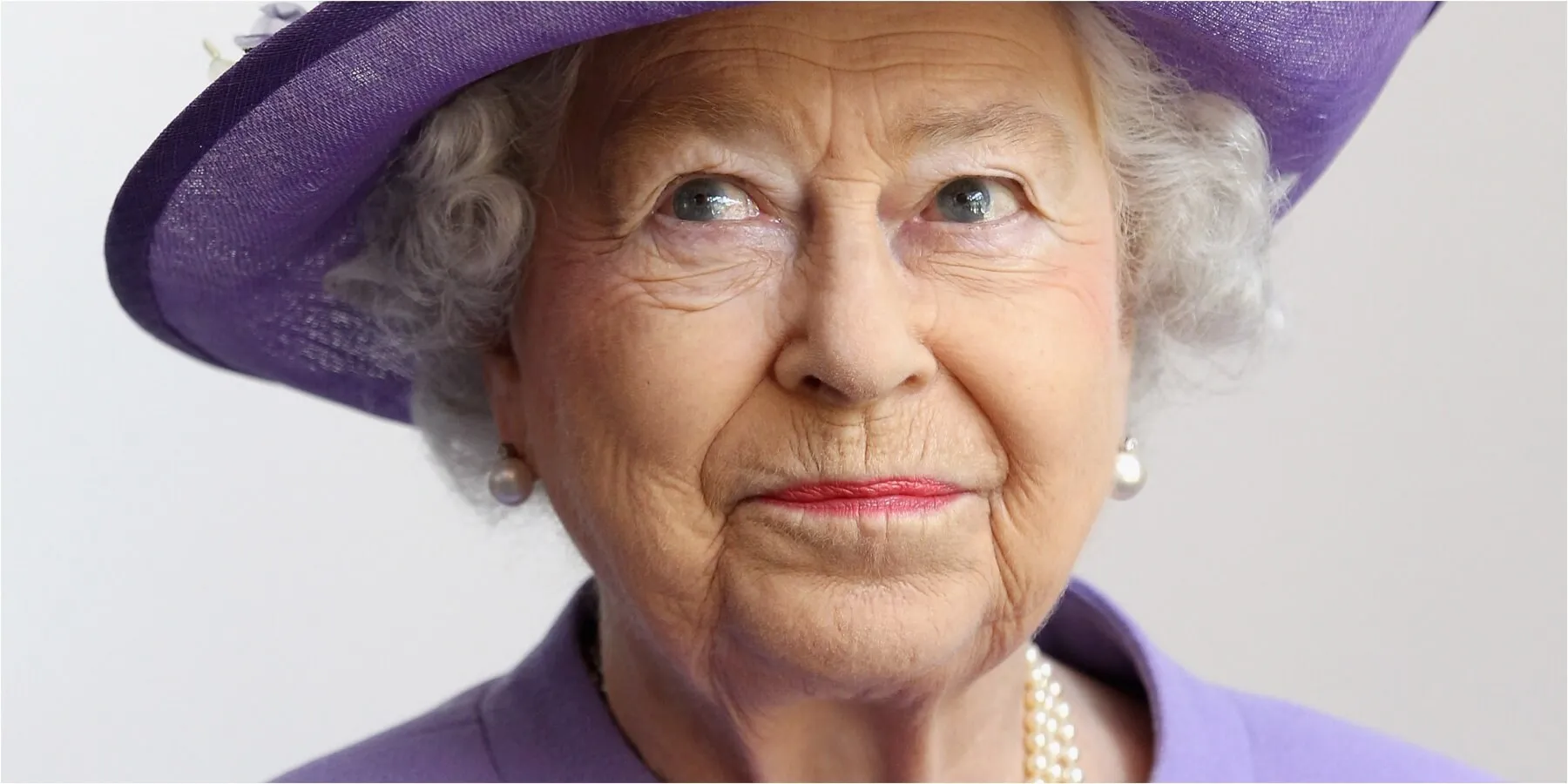 A photograph of Queen Elizabeth wearing a purple hat