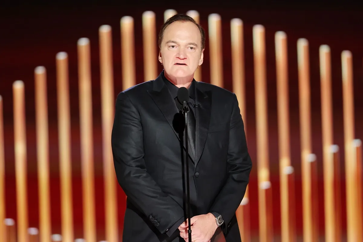 Quentin Tarantino speaks onstage at the 80th Annual Golden Globe Awards while wearing a black suit.