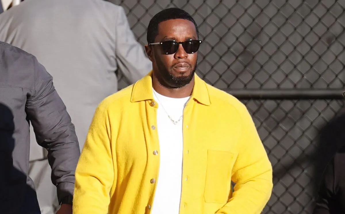 Sean 'Diddy' Combs walking outside in a yellow jacket and white T-shirt in 2023