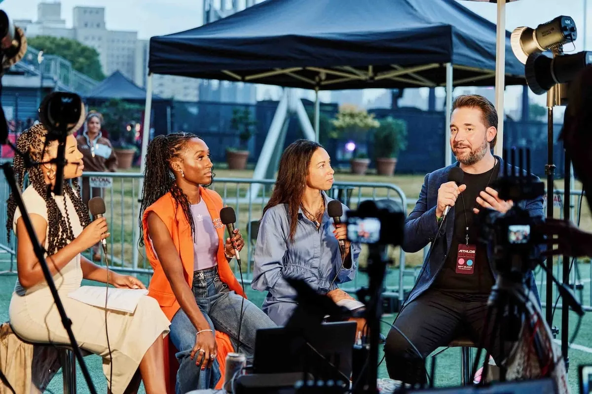 Athlos founder Alexis Ohanian speaks into the microphone during a media interview at Athlos NYC 2024