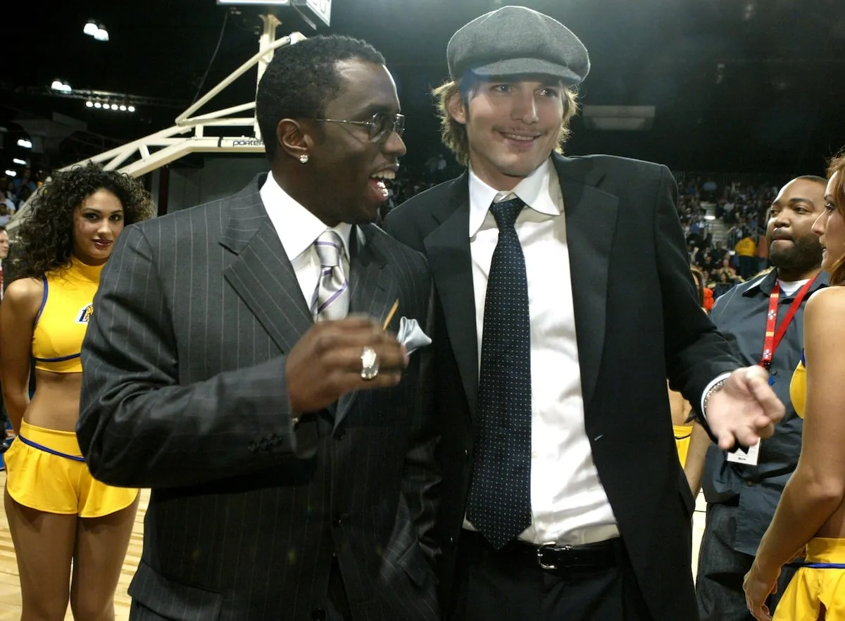 Rapper Sean 'Diddy' Combs laughs with Ashton Kutcher at a Lakers game in 2004