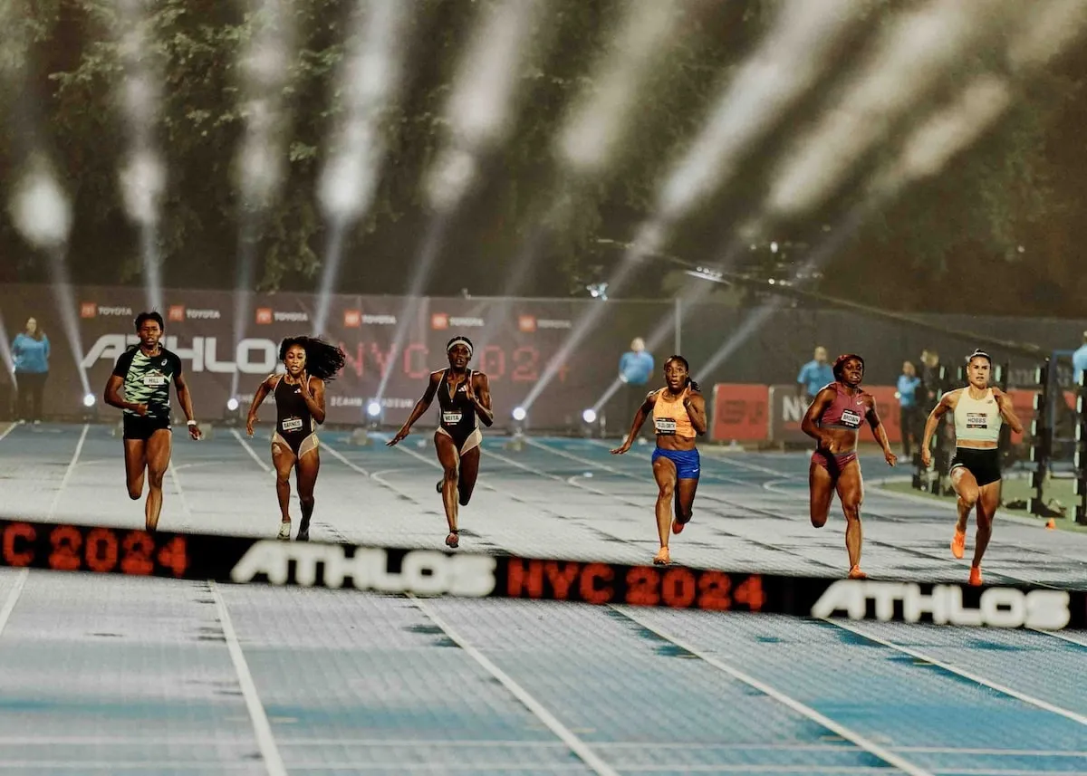 Six female runners sprint during the 100m race at the Athlos NYC track meet