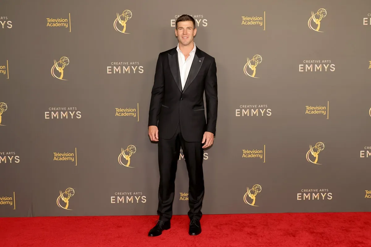 Austin Stowell posing in a suit at the Emmys.