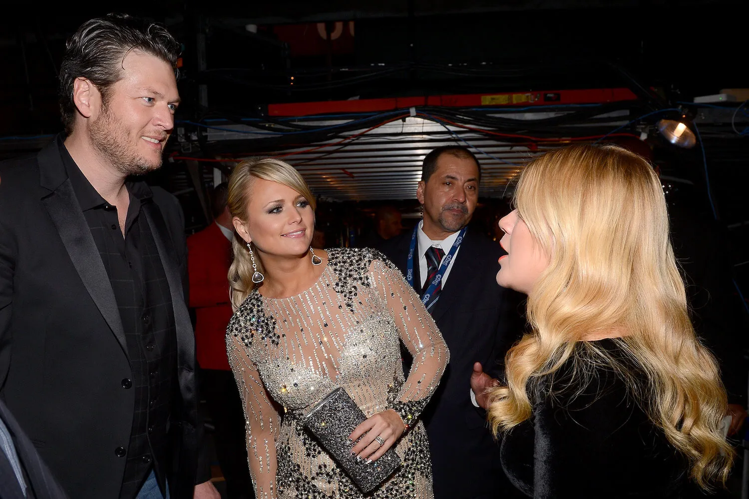 Blake Shelton, Miranda Lambert, and Kelly Clarkson speaking to each other at the Grammy Awards in 2013