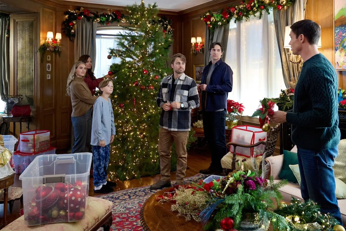 Family standing around a Christmas tree with boxes of decorations