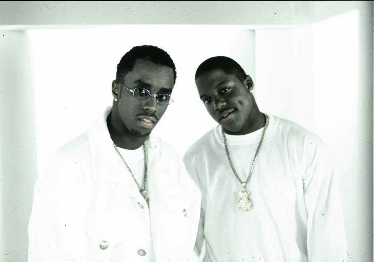 A black and white picture of Sean 'Diddy' Combs and Bad Boy artist Mase wearing white with necklaces.