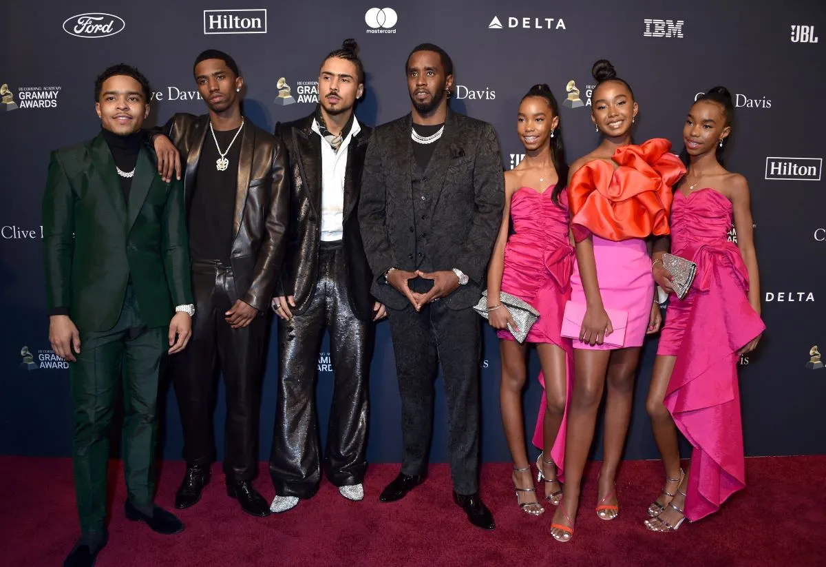 Sean 'Diddy' Combs stands surrounded by his children on a red carpet.