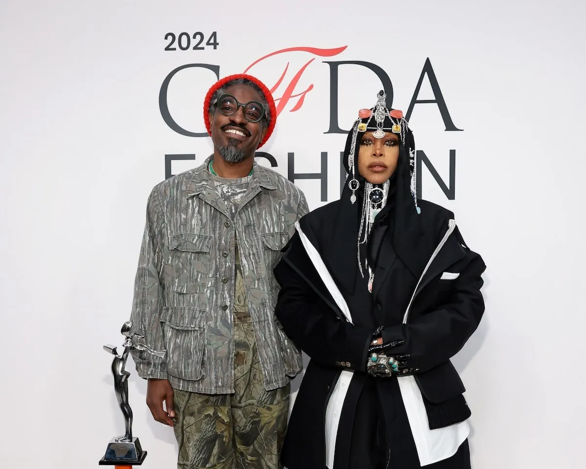 Wearing a black coat, dress, and headpiece, Erykah Badu poses with ex-husband Andre 3000 for photos at the CFDA Fashion Awards 2024