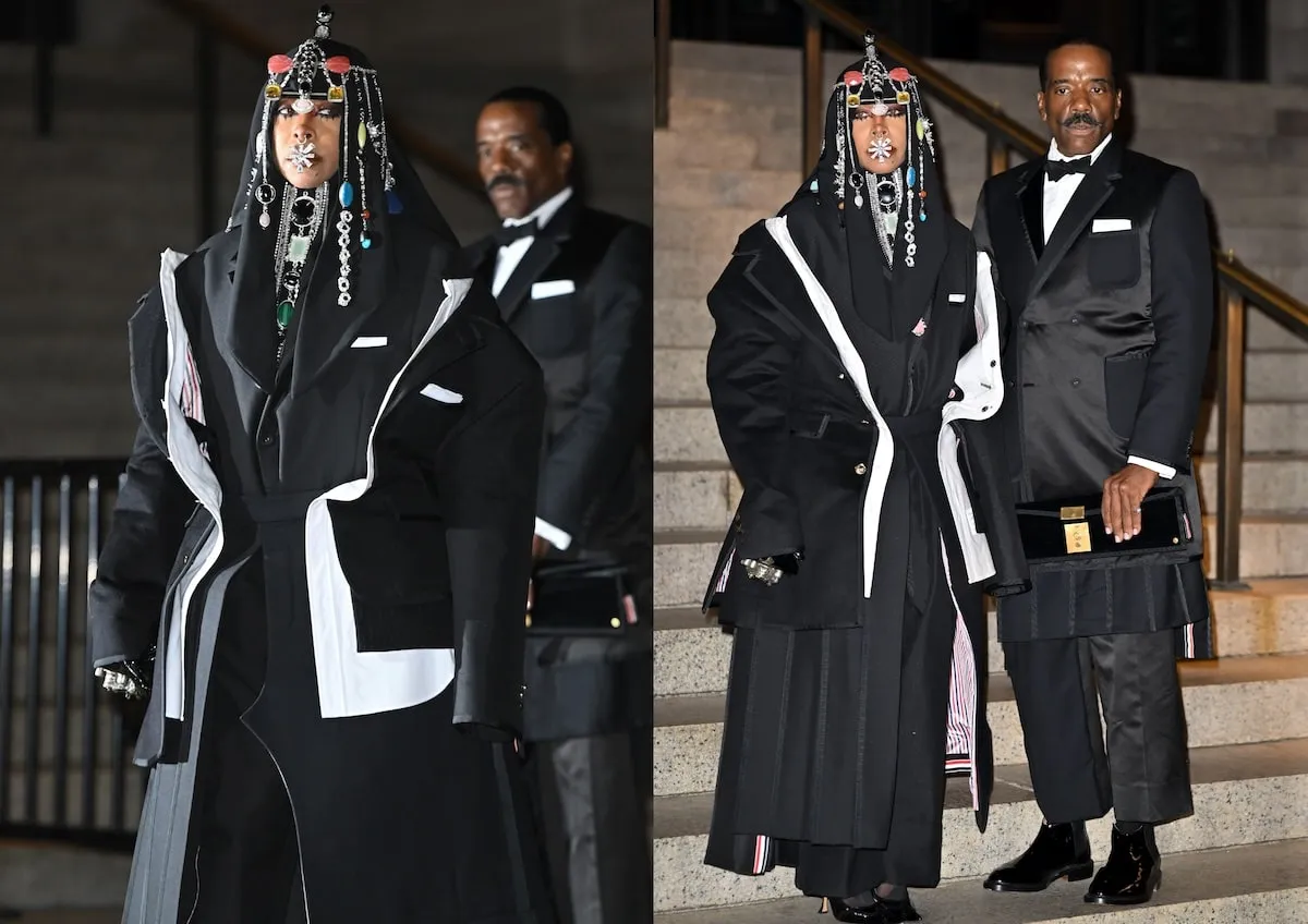 Wearing a black coat, dress, and headpiece, Erykah Badu stands with her date, Alfredo Gray, outside of the CFDA Fashion Awards 2024