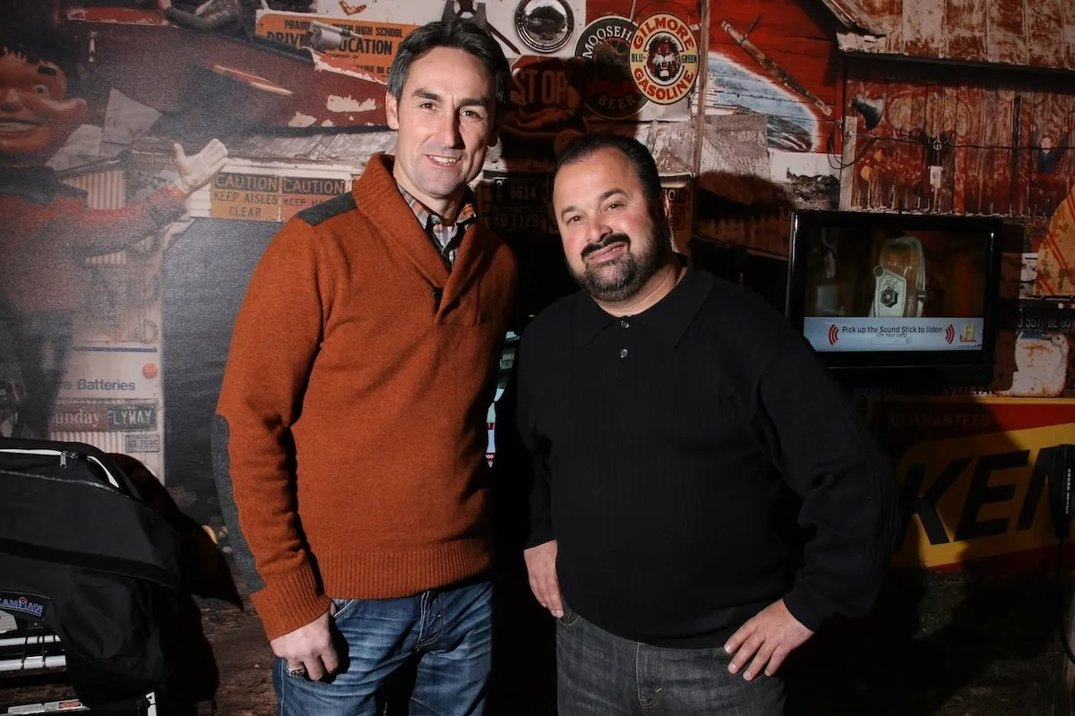 American Pickers stars Frank Fritz, wearing a black sweater, and Mike Wolfe, wearing a red sweater, stand together at a media event in 2010