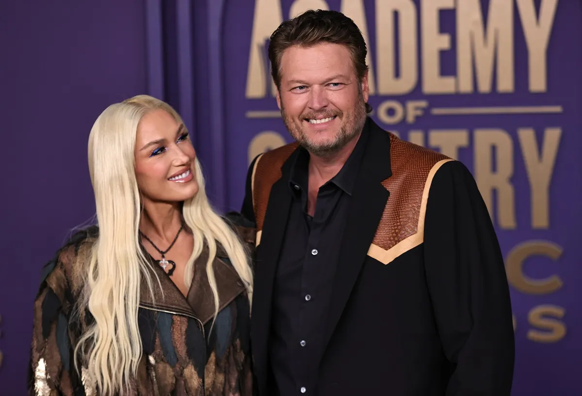 Gwen Stefani looking at Blake Shelton while they pose at the 59th Academy of Country Music Awards.