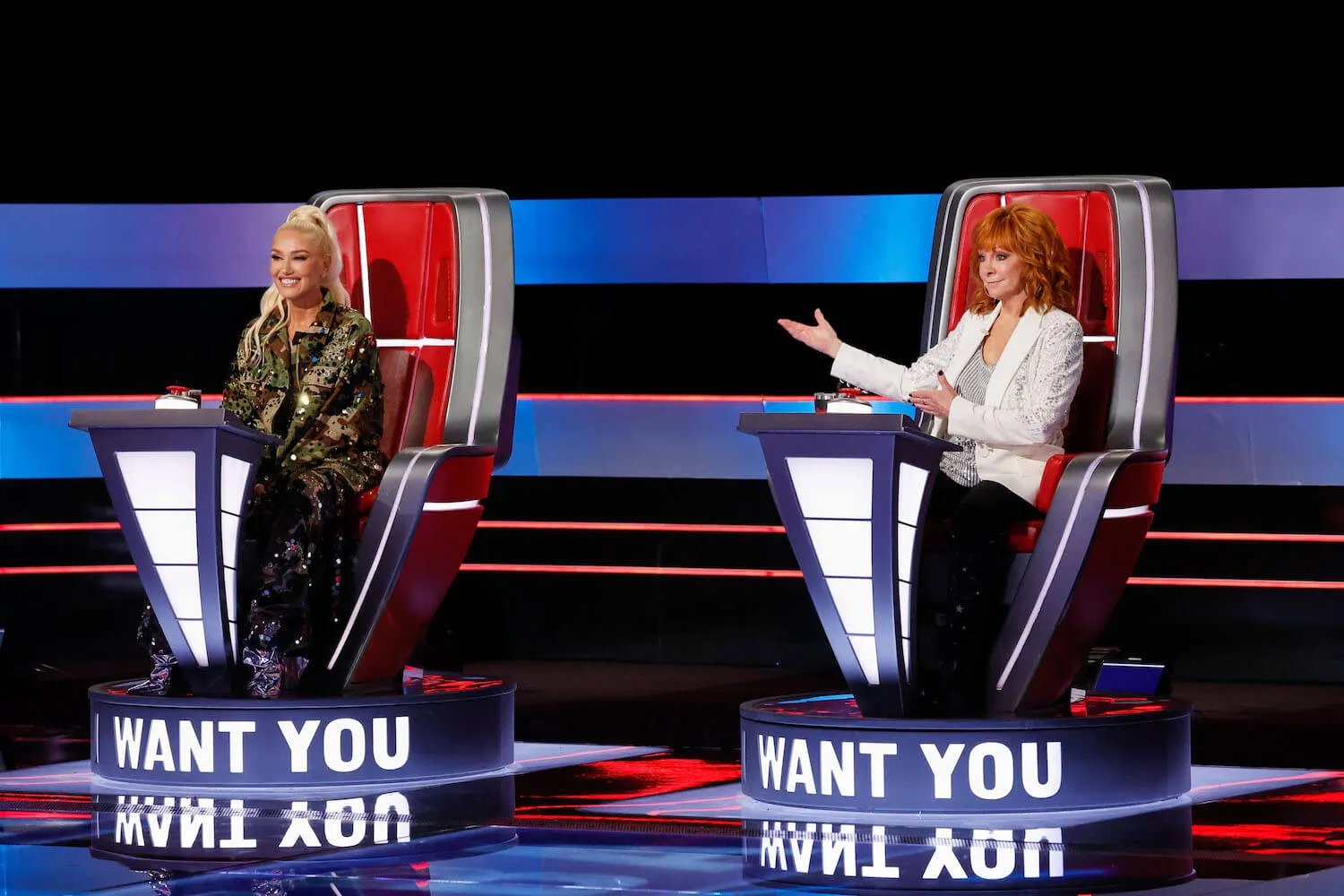 Gwen Stefani and Reba McEntire sitting in their chairs on 'The Voice' Season 26