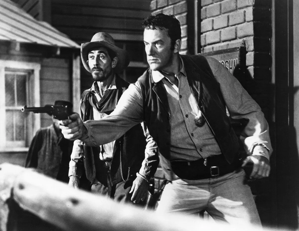 Black and white photo of James Arness as Matt Dillon shooting a gun