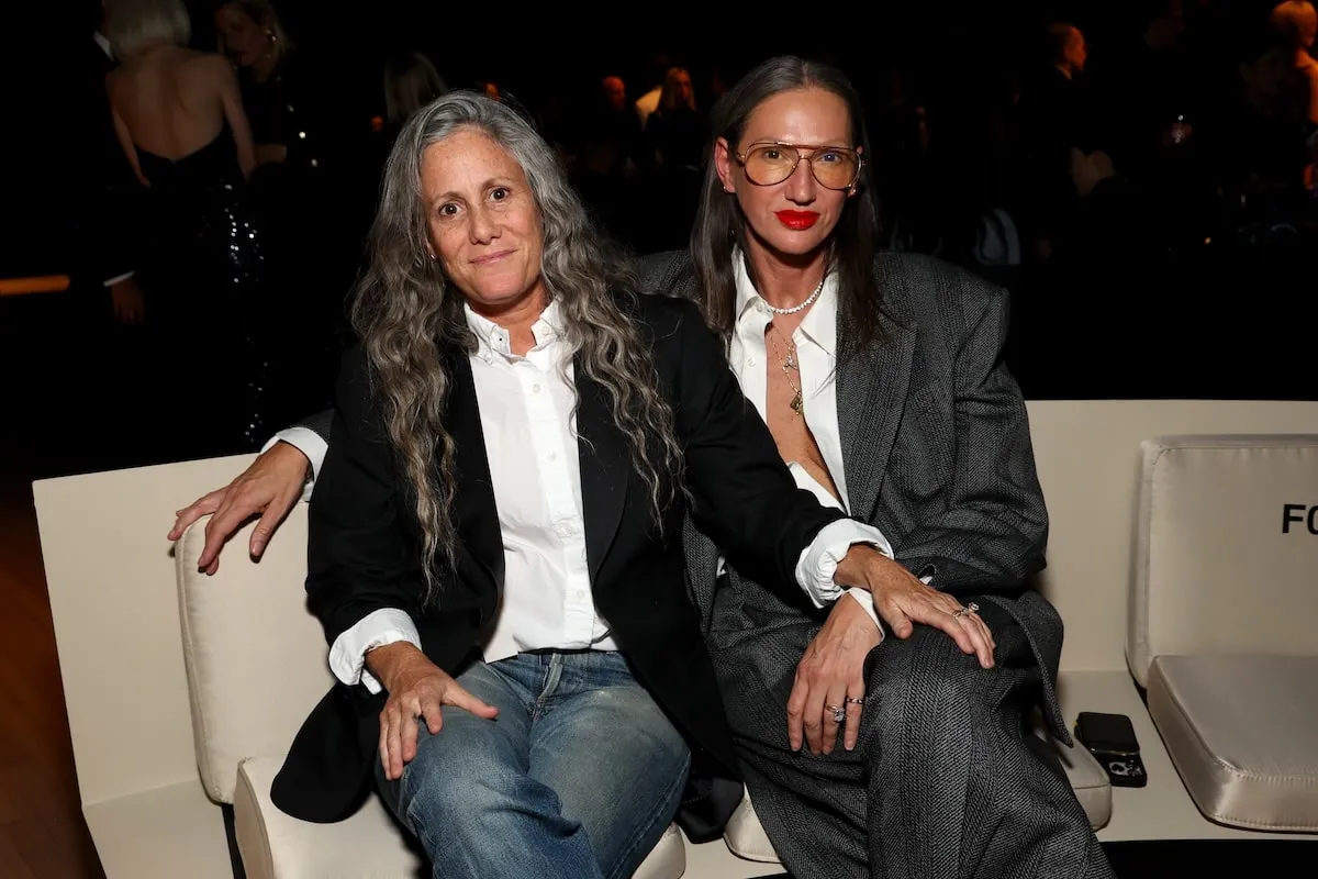 Engaged couple Cass Bird and Jenna Lyons sit together at the Giorgio Armani Women's SS25 Fashion Show