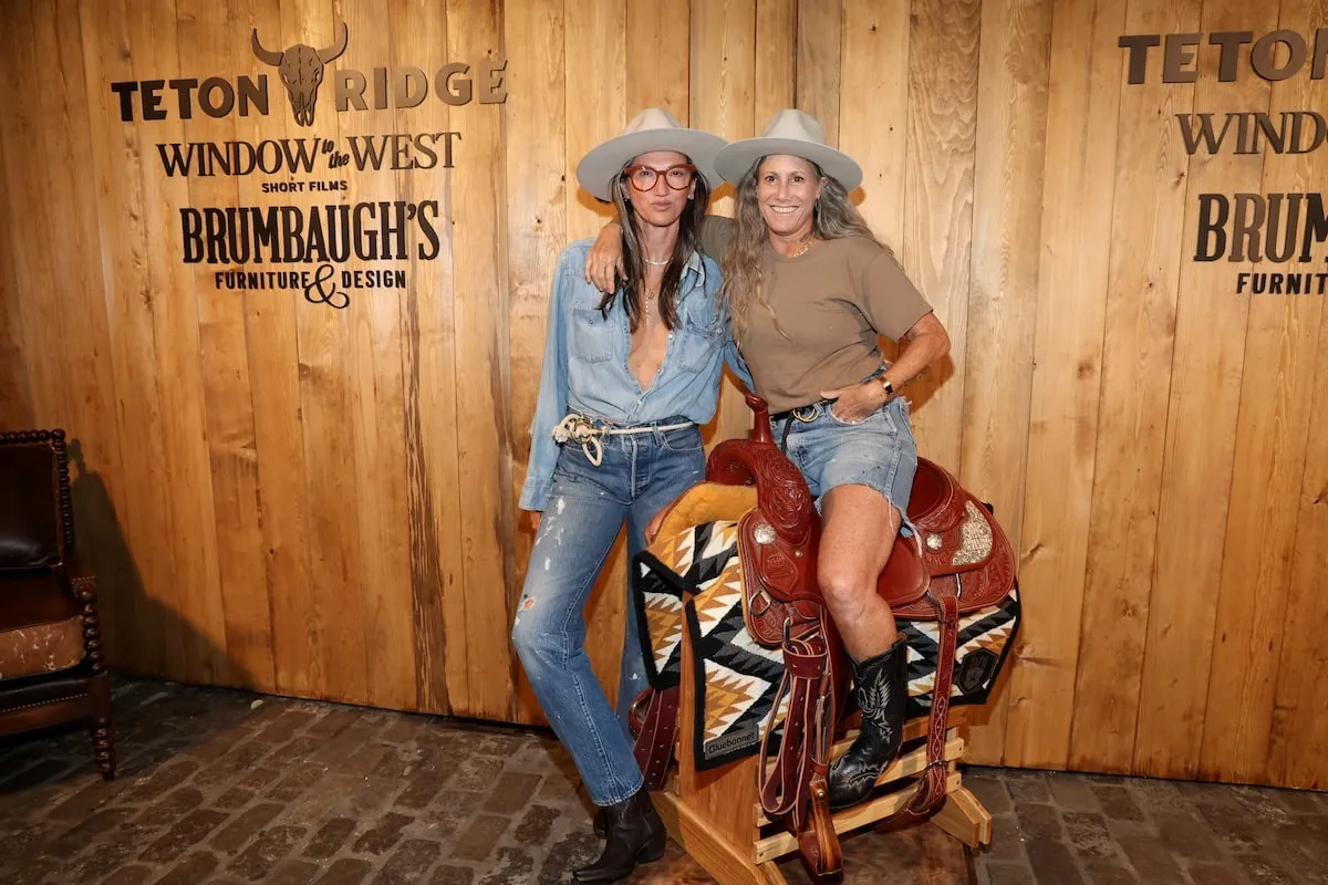 Engaged couple Jenna Lyons and Cass Bird sit on a saddle at a Western bar