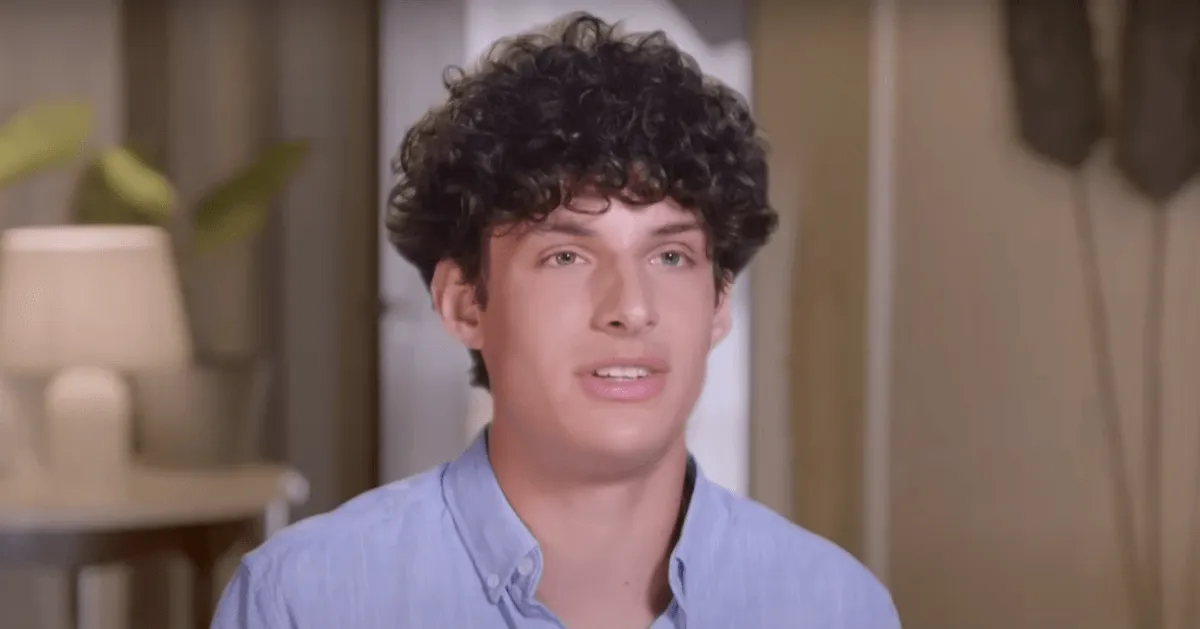 Young man with curly hair a blue button-down shirt