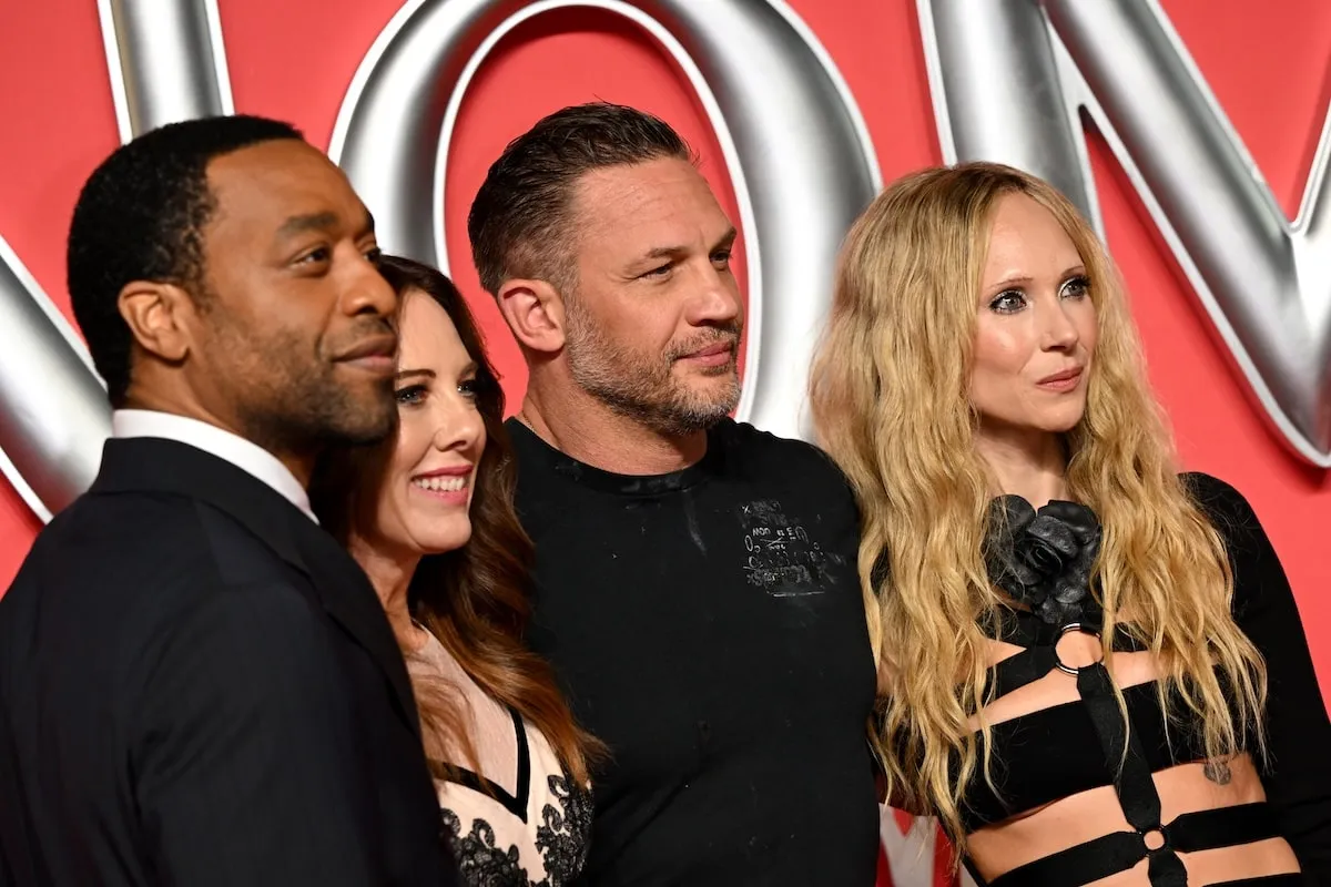 Venom: The Last Dance cast members Chiwetel Ejiofor, Kelly Marcel, Tom Hardy, and Juno Temple smile together on the red carpet