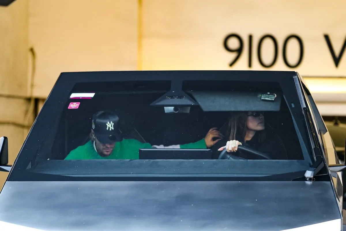 Driving their Tesla Cybertruck, Justin Bieber and Hailey Bieber look for traffic as they exit a parking garage in LA