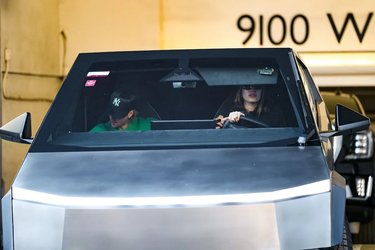 Driving their Tesla Cybertruck, Justin Bieber and Hailey Bieber look for traffic as they exit a parking garage in LA