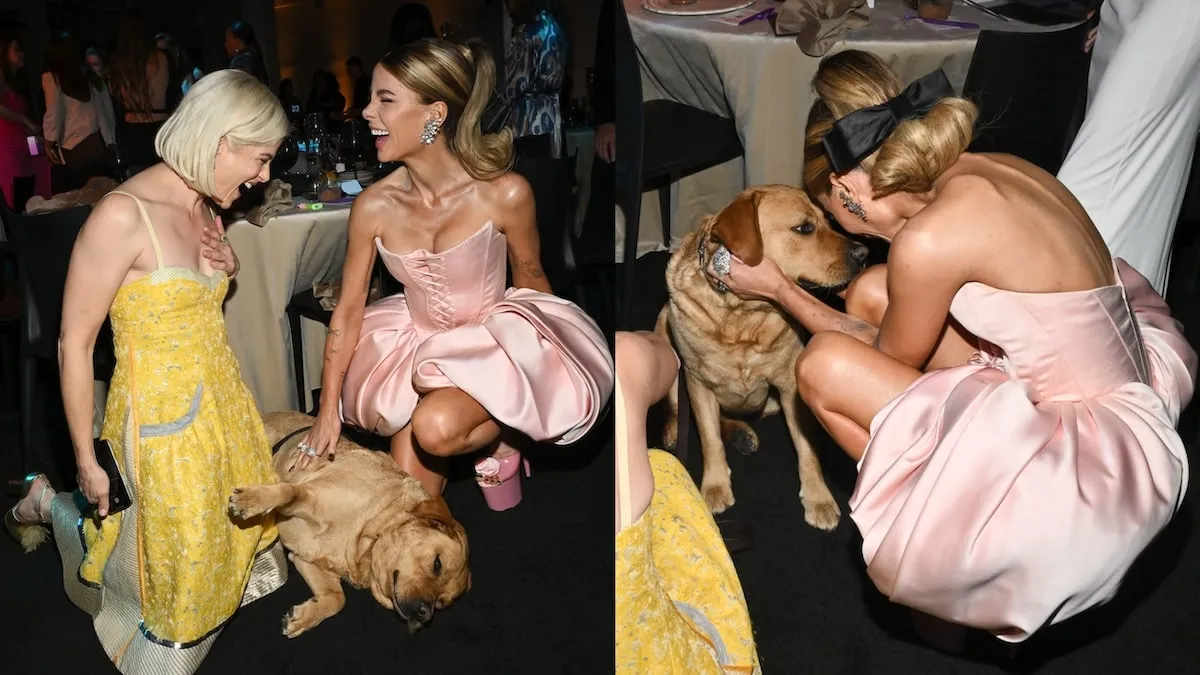 Wearing a yellow dress, Selma Blair crouches next to Kate Beckinsale on the ground as she pets Selma's service dog