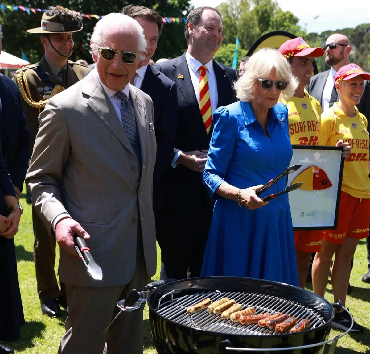 King Charles cooks sausages during the Premier's Community Barbeque at Parramatta Park in Sydney, Australia