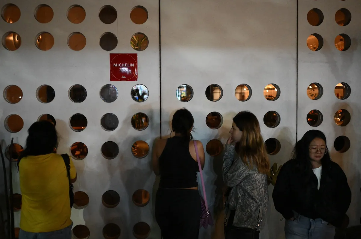 Fans peer through the round windows of the Casa Sur hotel