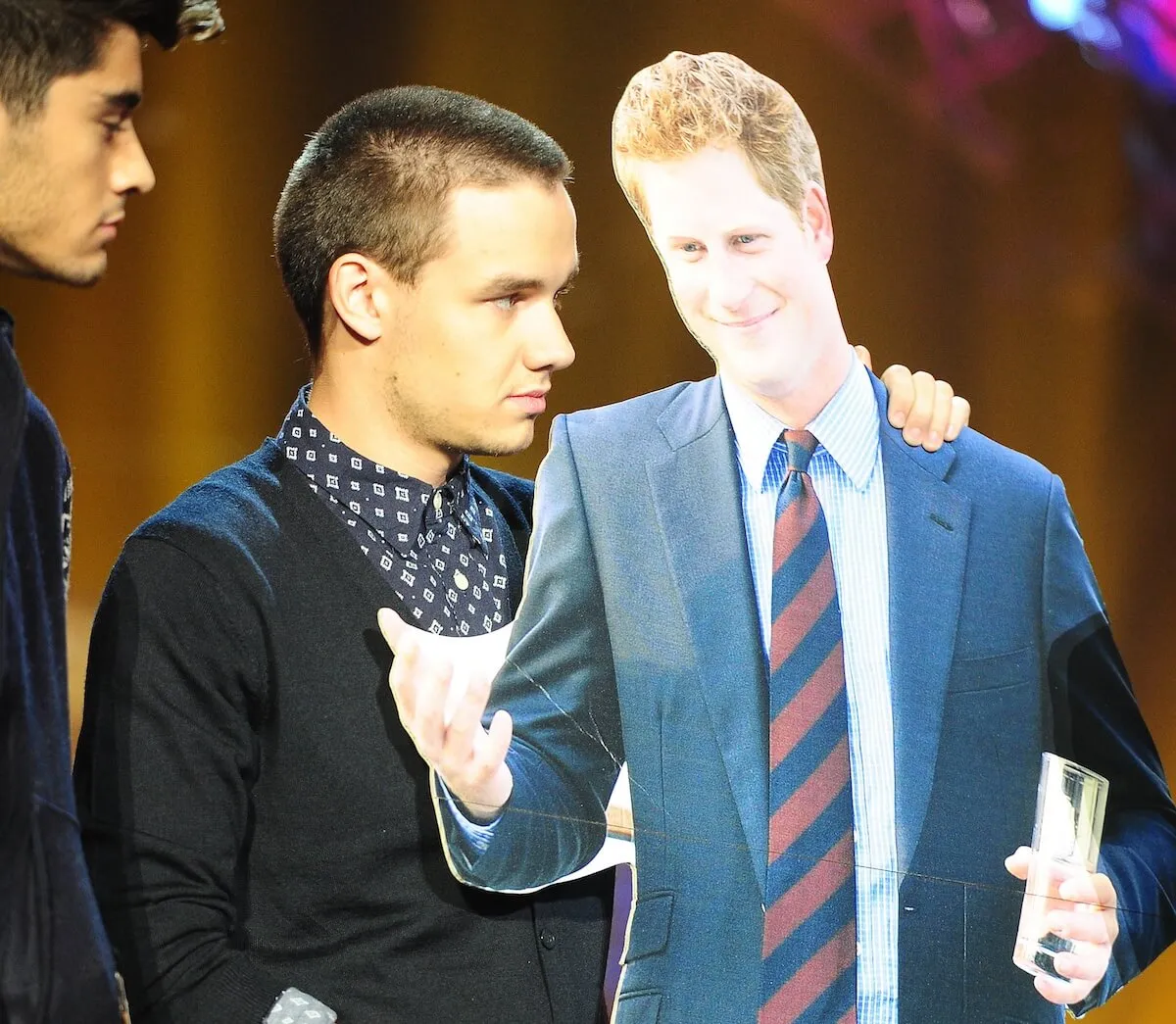 Liam Payne holds a cardboard cutout of Prince Harry in 2012