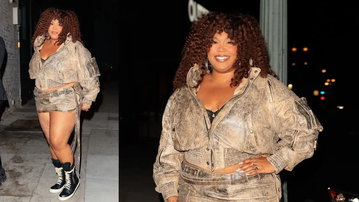 Singer Lizzo stops on the street to smile at paparazzi while wearing a two-piece leather outfit