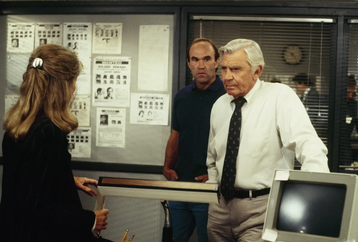 Andy Griffith in a white shirt and tie and standing by a computer in 'Matlock'