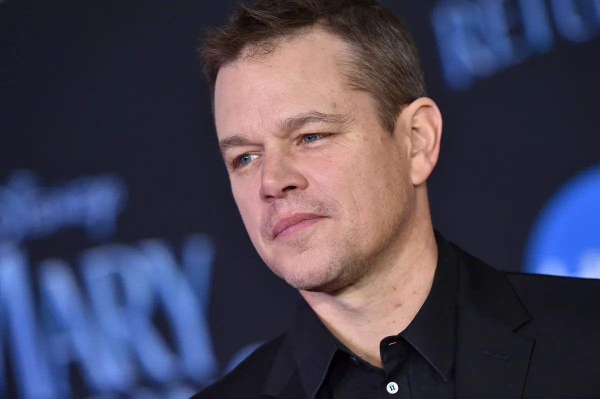 Matt Damon posing in a black suit at the premiere of 'Mary Poppins Returns'.