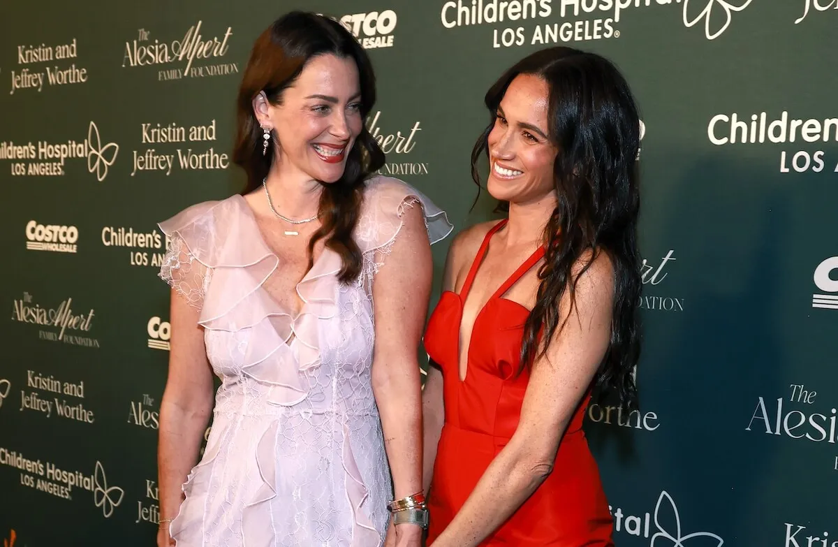 Meghan Markle wears a red Carolina Herrera dress as she poses with Kelly Zajfe