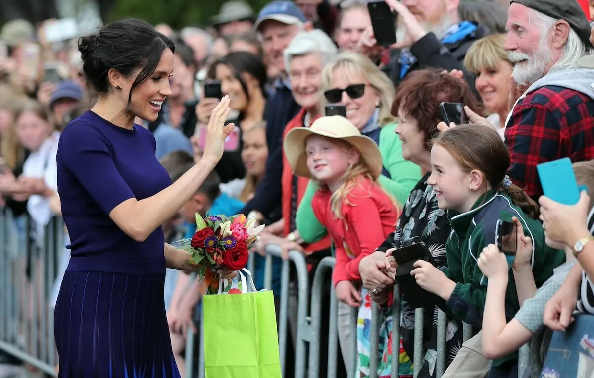 Meghan Markle greets fans during a royal walkabout in 2018