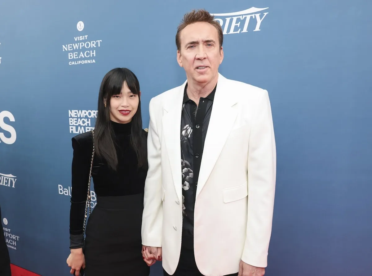 Walking the red carpet in a black dress and white tuxedo, Riko Shibata and Nicolas Cage stop for a photo at the 25th Newport Beach Film Festival Honors Brunch