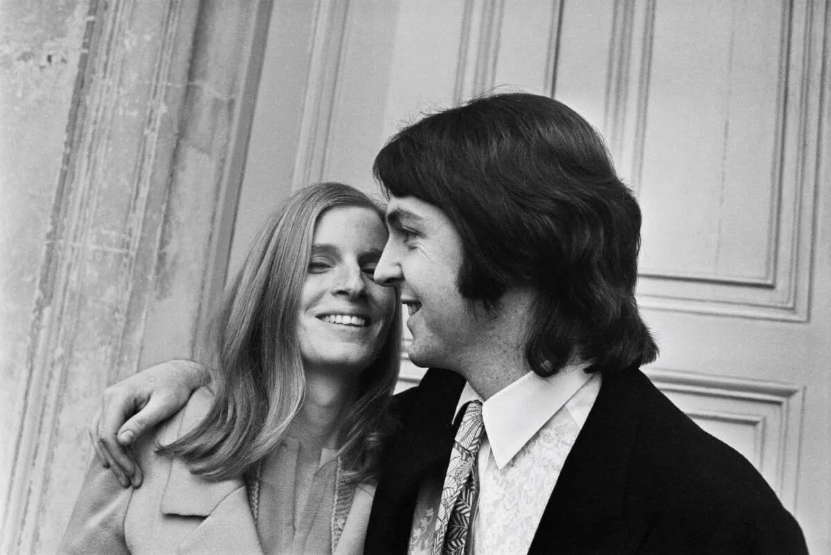 A black and white picture of Paul and Linda McCartney standing together on their wedding day.