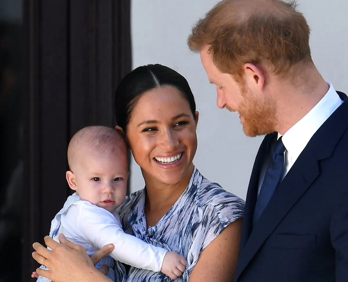 Prince Harry, Duke of Sussex, Meghan, Duchess of Sussex, and their baby son Archie Mountbatten-Windsor in 2019. Meghan is holding Archie and smiling.