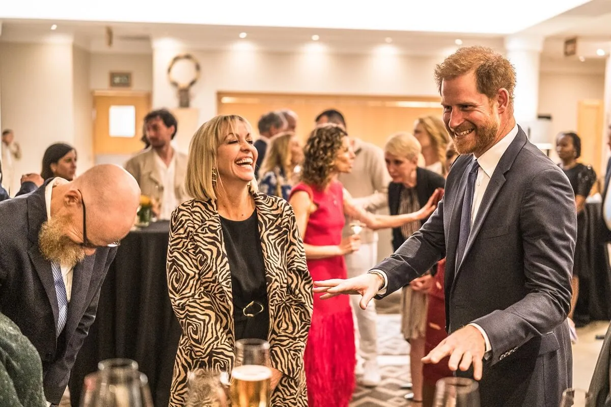 Prince Harry laughing and mingling with guests at a Sentebale reception in Johannesburg, South Africa