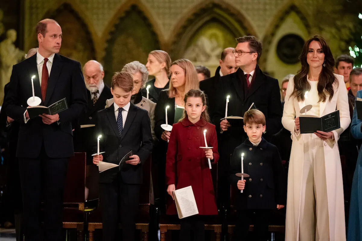 Prince William, Prince George, Princess Charlotte, Prince Louis, and Kate Middleton at a Christmas carol concert holding candles. 