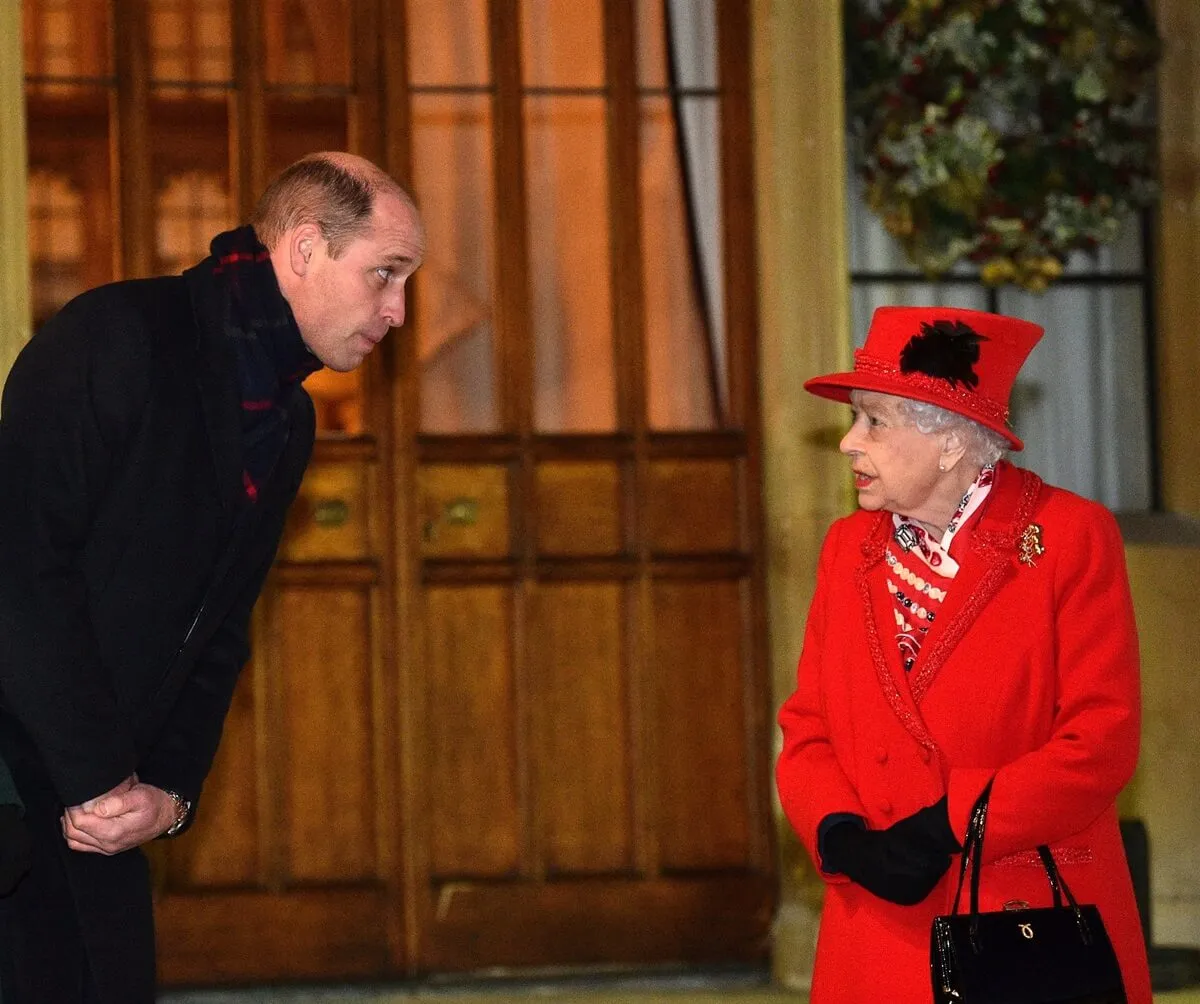 Prince William and Queen Elizabeth talk as they await volunteers outside Windsor Castle