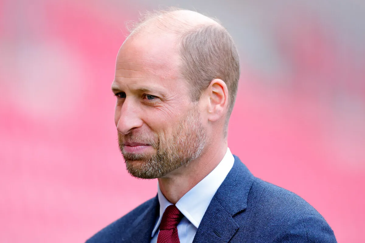 Prince William, who has a forthcoming documentary on homelessness, smirks wearing a suit and tie