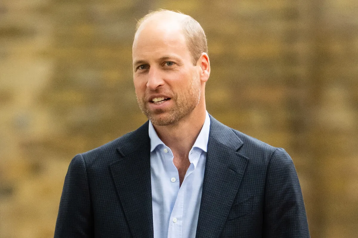 Prince William, who has changed his look, looks on wearing a blazer and open shirt.