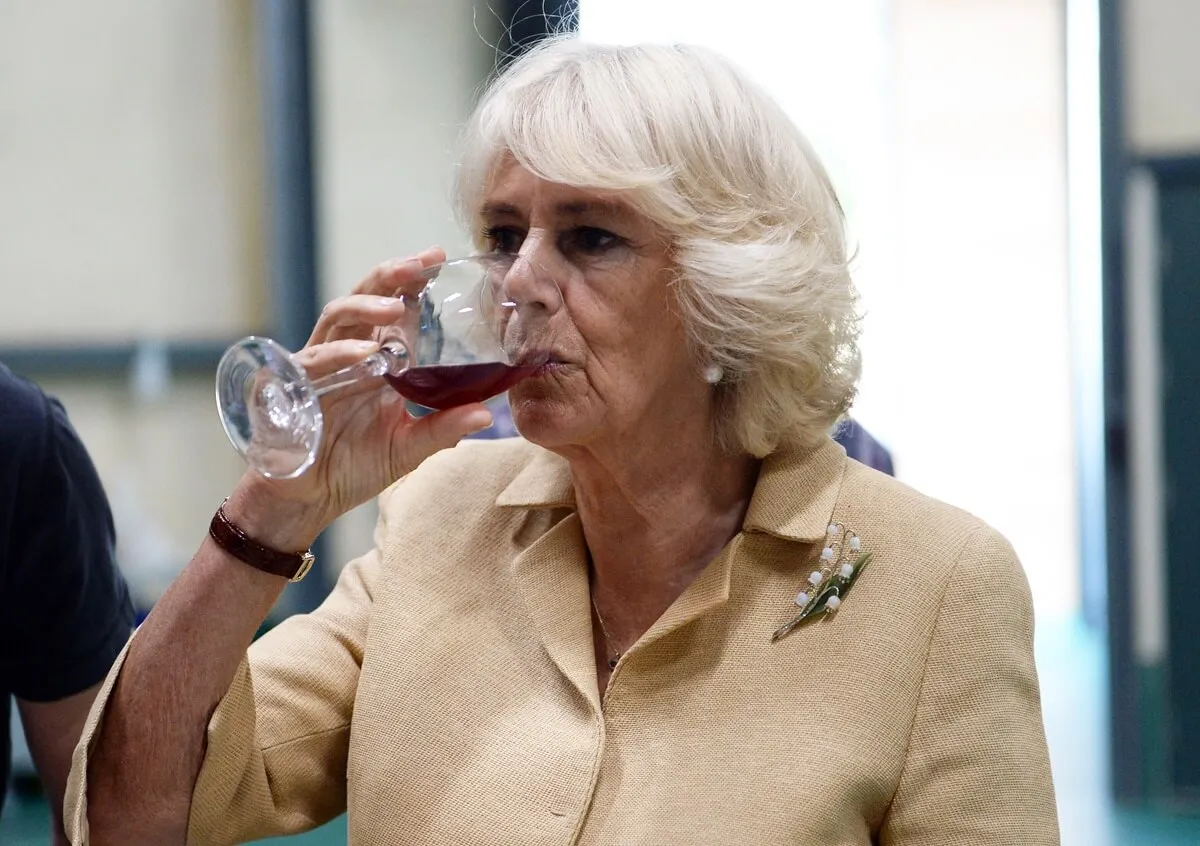 Queen Camilla (formerly Camilla Parker Bowles) samples a glass of wine as she tours Ancre Hill vineyard in Wales