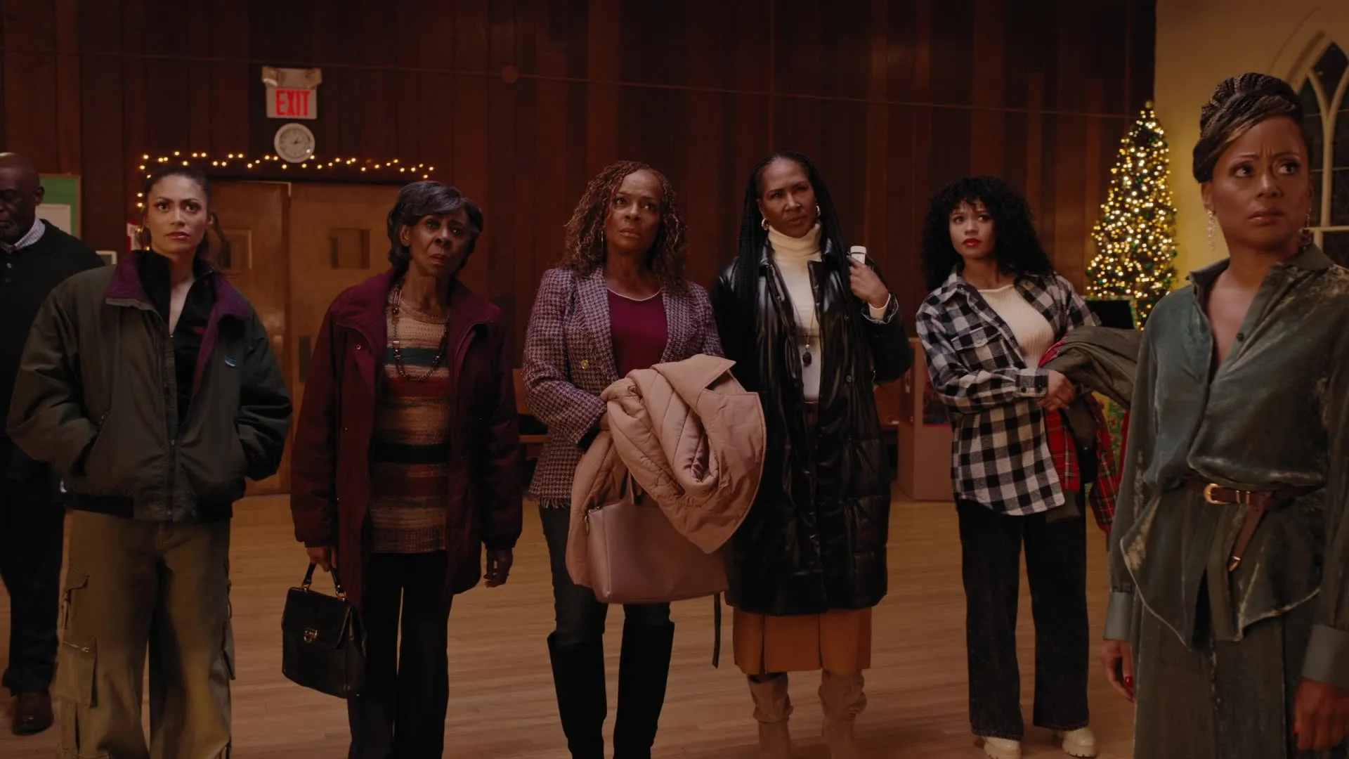 Group of people standing in front of Christmas decorations in 'Queens of Christmas'