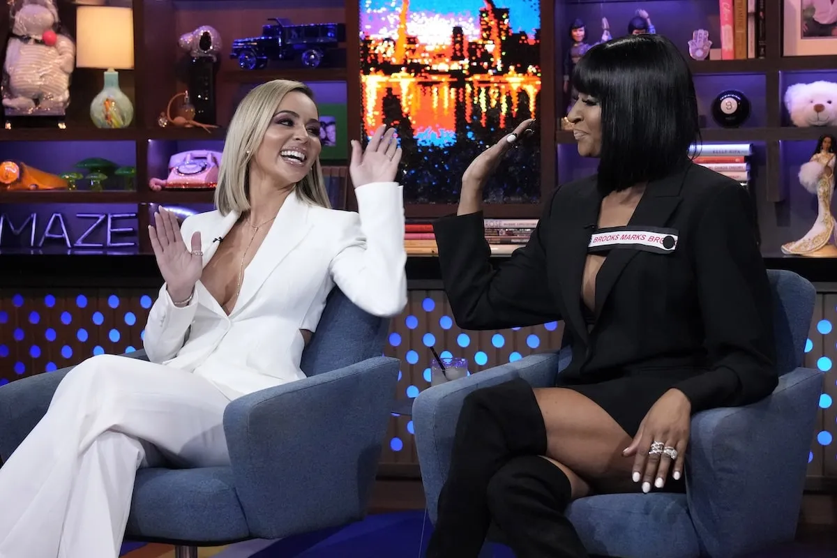 The Real Housewives of Miami stars Nicole Martin and Guerdy Abraira high five on Watch What Happens Live