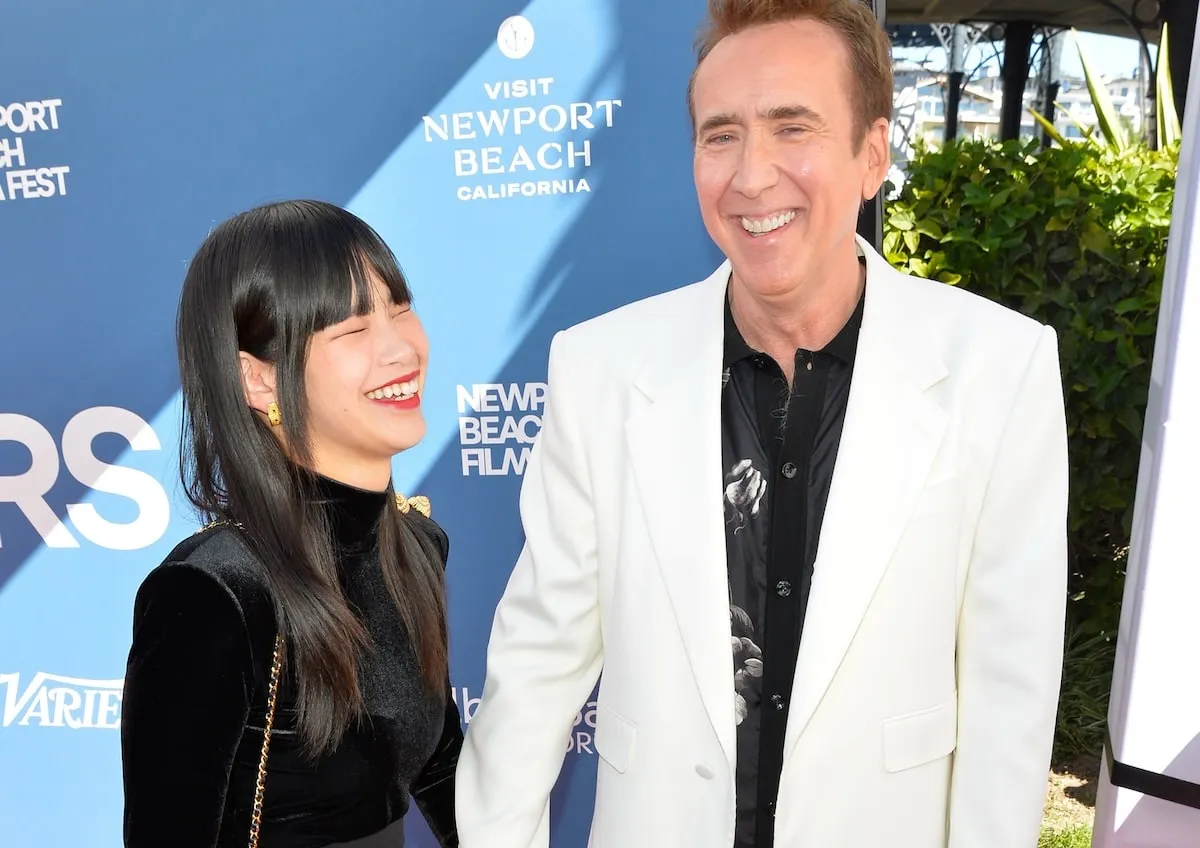 Walking the red carpet in a black dress and white tuxedo, Riko Shibata and Nicolas Cage stop for a photo at the 25th Newport Beach Film Festival Honors Brunch