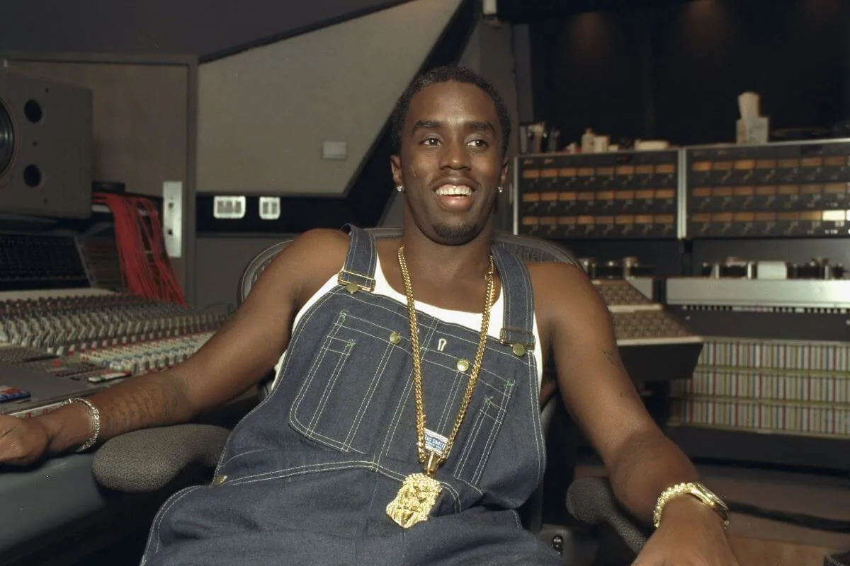 Sean "Diddy" Combs wears overalls and sits in the studio.