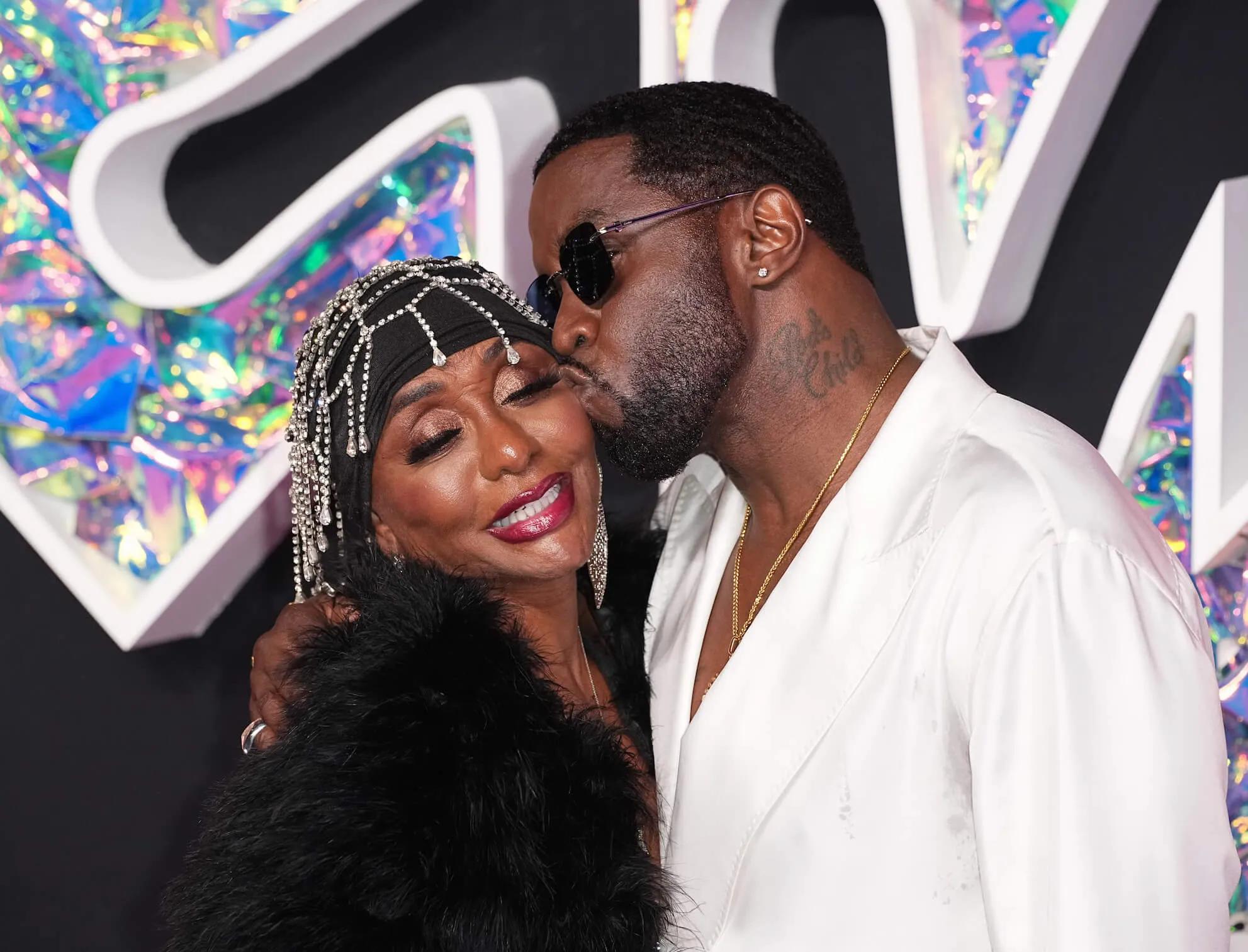 Sean 'Diddy' Combs kissing the side of Janice Smalls Combs' face at an event in 2003. They are both dressed up.