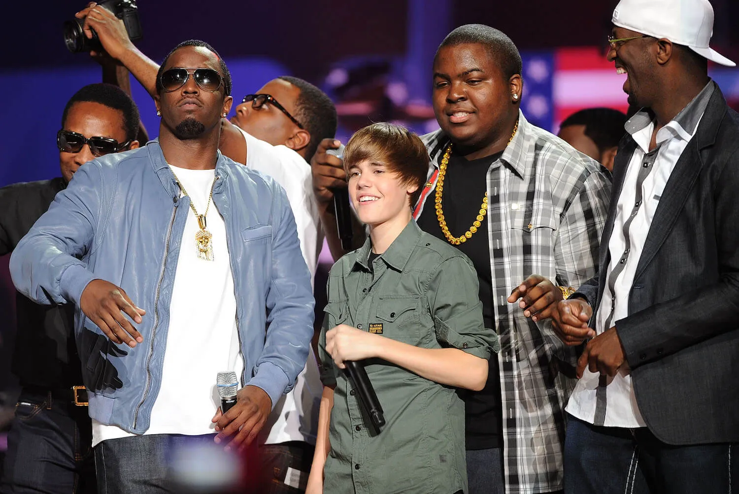 Sean 'Diddy' Combs and Justin Bieber standing on stage with other celebrities for a benefit concert in 2010