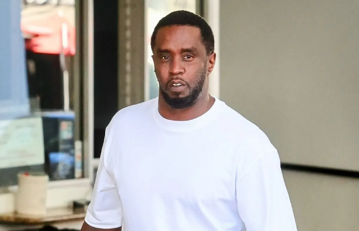 Sean 'Diddy' Combs wears a white shirt and walks outside.